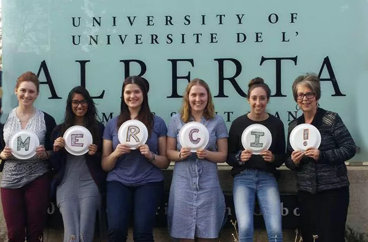 Un groupe de femmes devant l&#039;affiche de l&#039;université de l&#039;Alberta