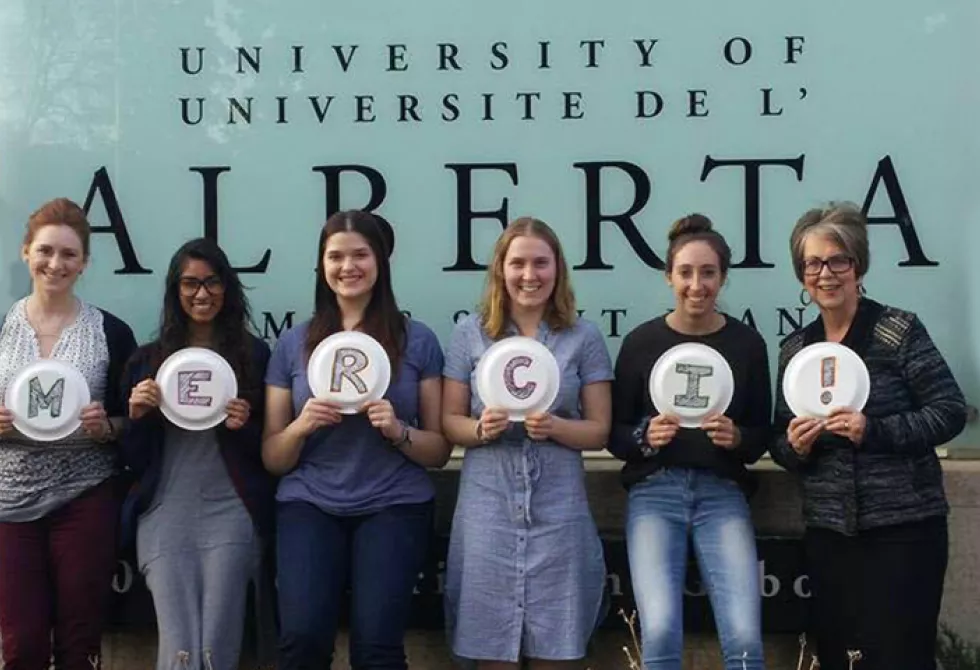 Un groupe de femmes devant l&#039;affiche de l&#039;université de l&#039;Alberta